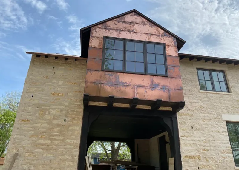 Copper metal panel facade on a stone building for Skylight Installation in Blackstone